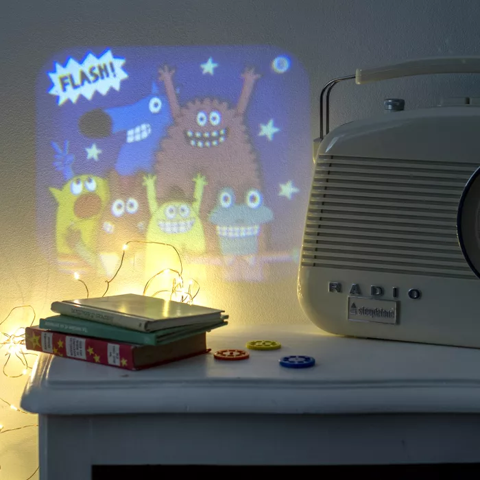 projektor-bajki-gradska-beba2 Moulin Roty ‘Lanterne à histoires Les Schmouks’ — trostruka lampa: projektor priča, projektor senki i noćna lampica sa 32 slike za razvijanje mašte i pričanje bajki. Idealan poklon za decu od oko 4 godine.